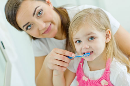 Mom and Daughter brushing their teeth - Pediatric Dentist in Madison, MS